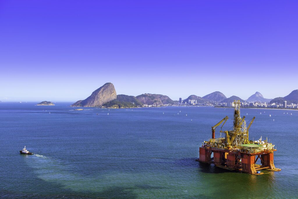 An oil rig with the coast in the background.