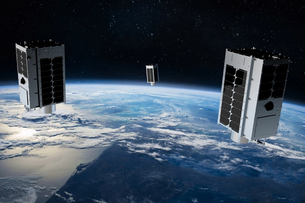 Three satellites orbiting over Earth.