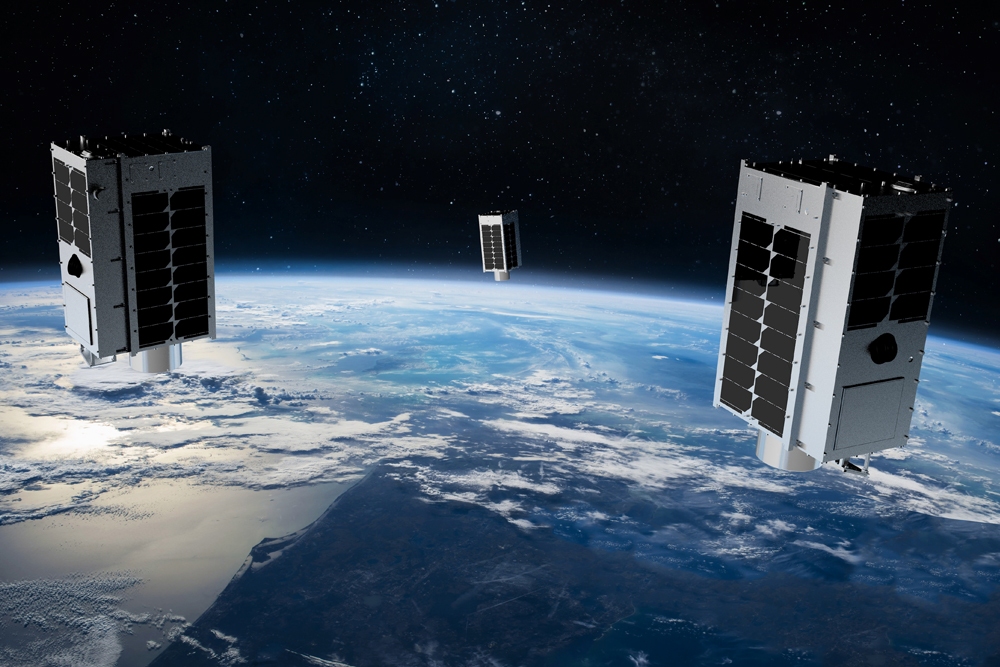 Three satellites orbiting over Earth.