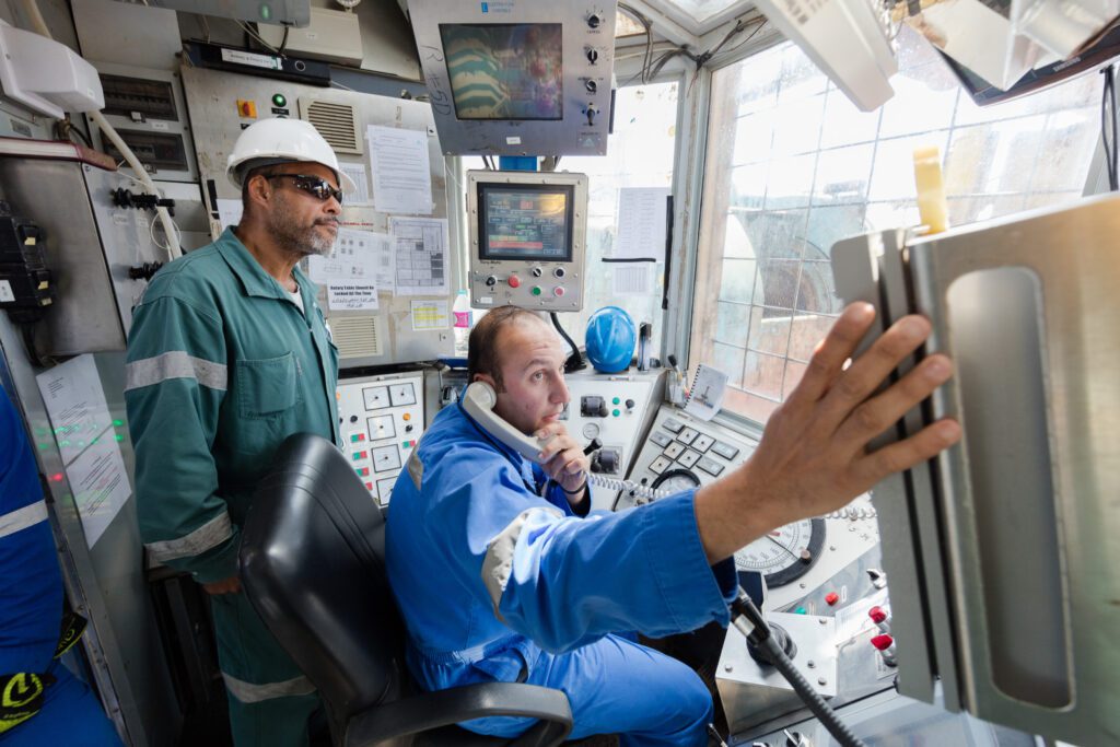 Two male employees working int he control room of Mocha-1 onshore drill rig.
